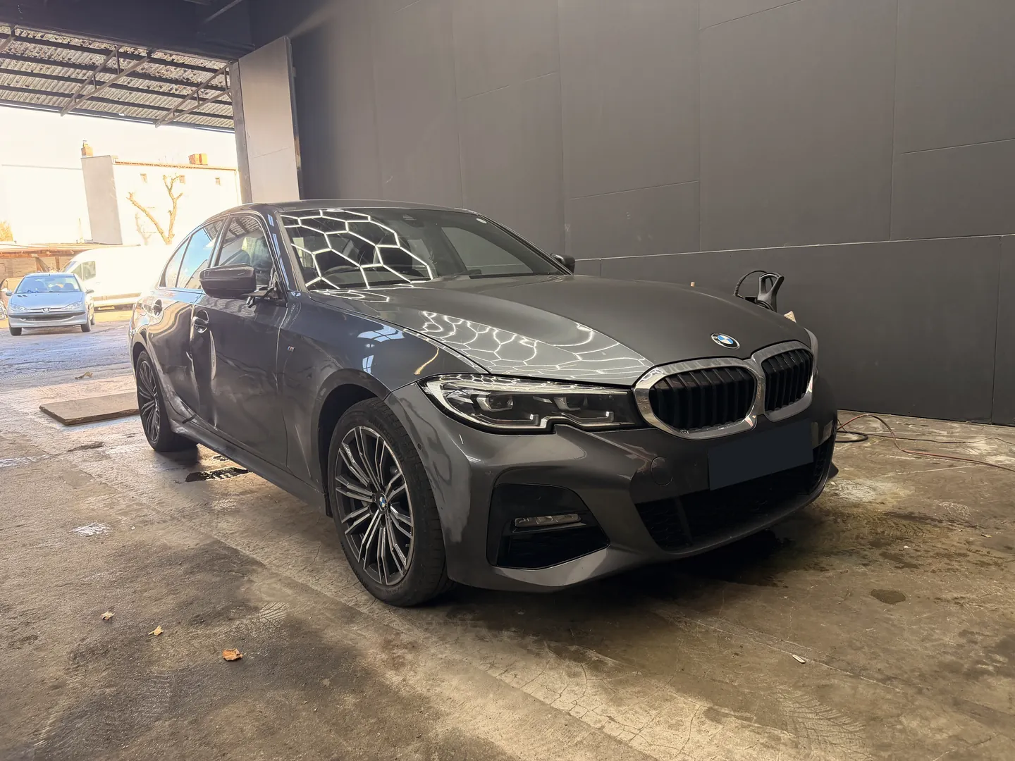 Originale Fahrzeugaufnahme einer grauen BMW-Limousine, Kennzeichen verdeckt