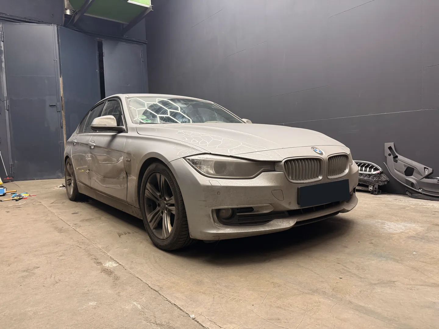 Originalfoto eines silbernen BMW mit Seitenschaden, Kennzeichen verdeckt